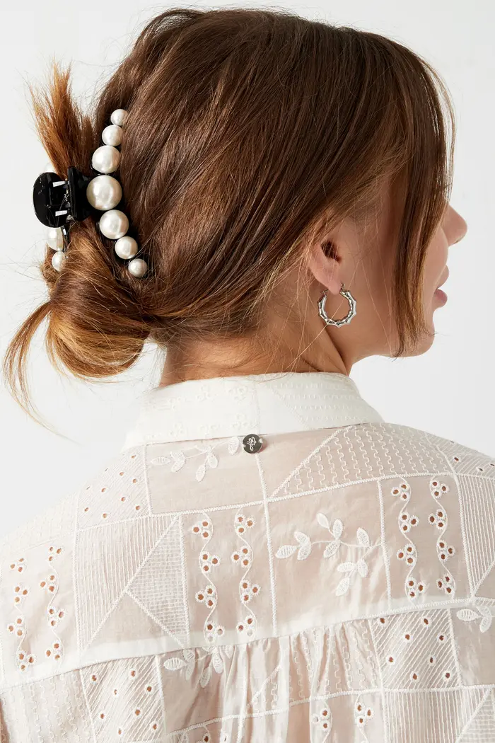 Vrouw met parel haarspeld en oorring.